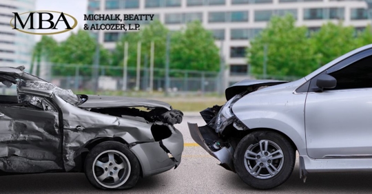 two dented cars after crashing